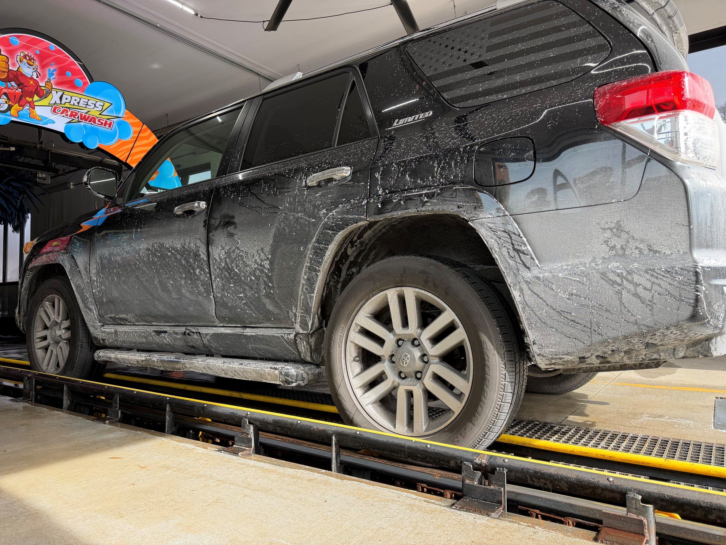 A mud-caked black 4Runner on the conveyor at the tunnel entrance