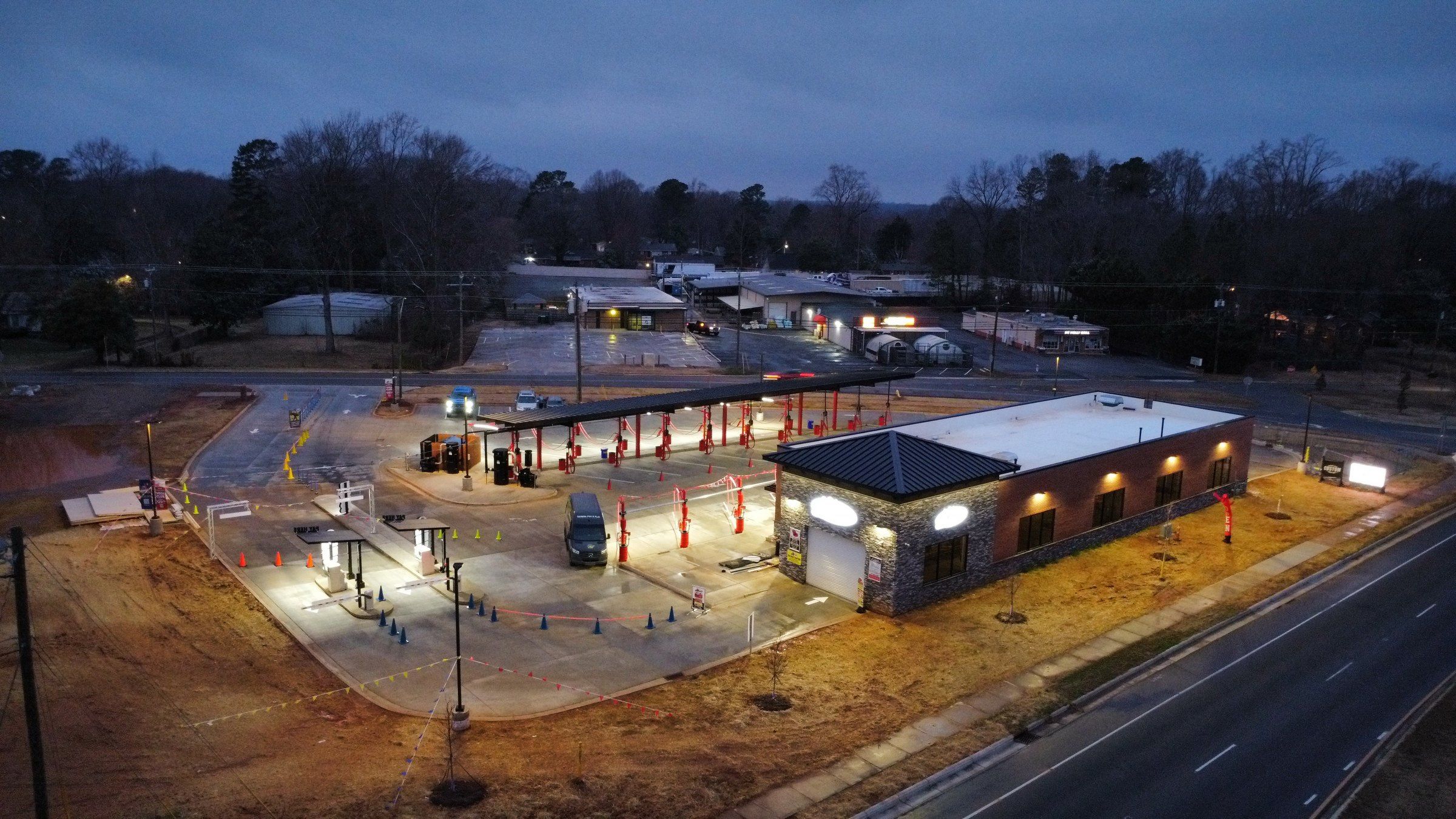 Tiger Xpress Car Wash from above at dusk: the brick wash building, the red vacuum canopy and Beatty Dr.