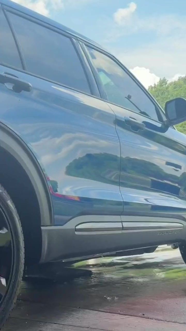 A clean blue SUV rolls out of the tunnel into daylight