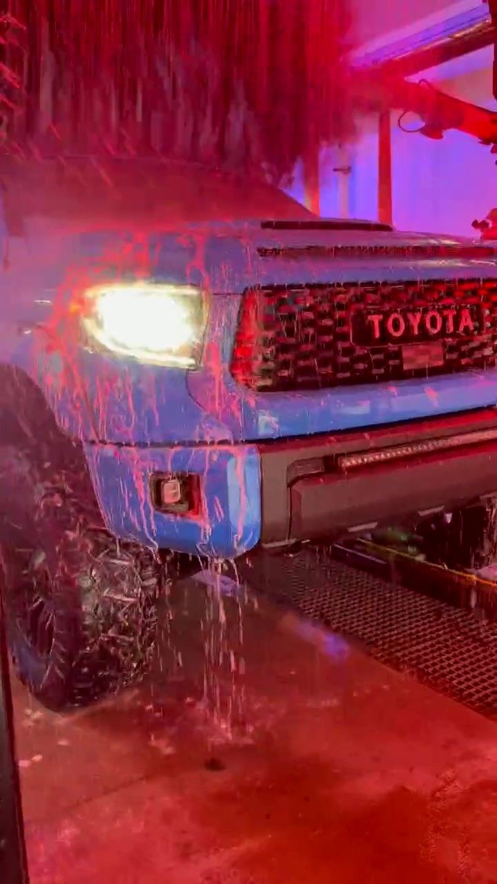 A Toyota rolls under the red-lit arch at the tunnel entrance